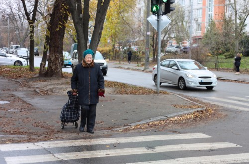 An old lady crossing a busy road